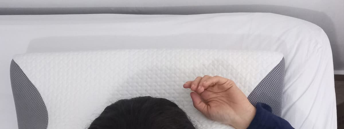 Travesseiro Cervical em uso, com a mão apoiada sobre a asa